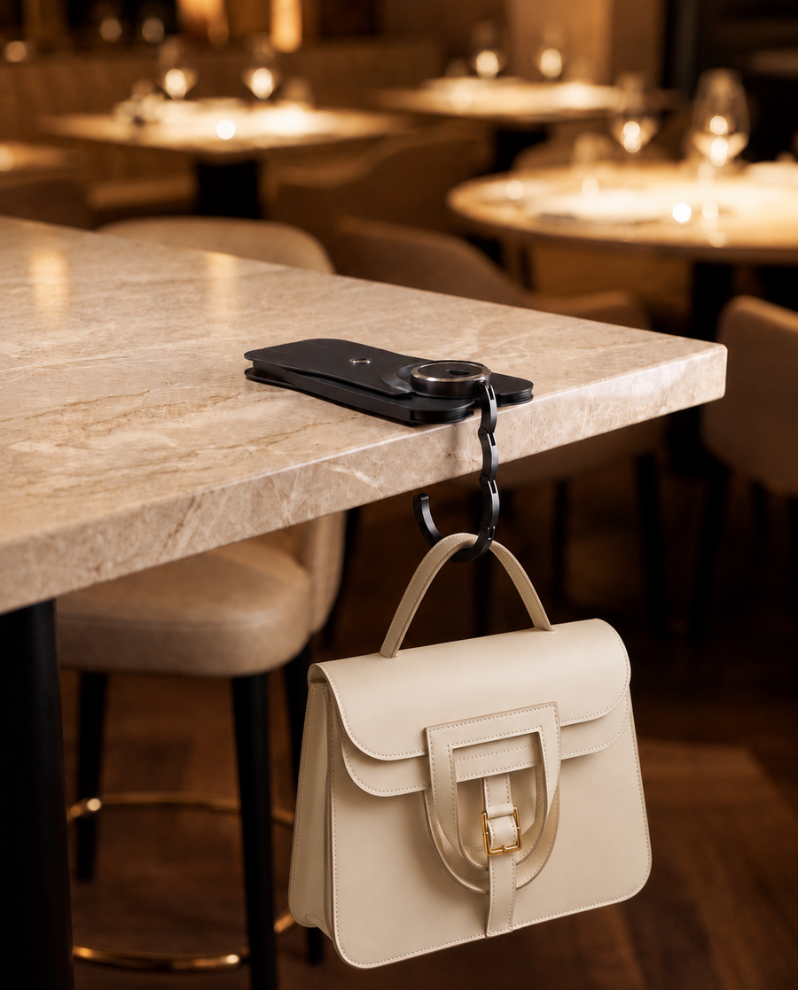 Winger hooked over a restaurant table edge, holding a bag off the floor
